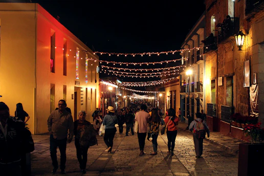 A lively city street at night with couples meeting and chatting under warm streetlights.