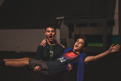 man lifting man in blue vest