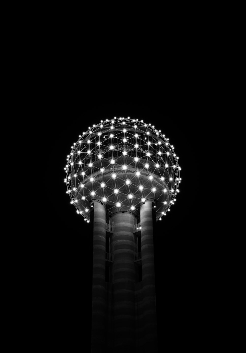 a black and white photo of a tower with lights on it