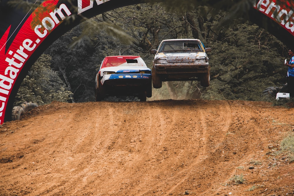 2 race cars on dirt track during daytime