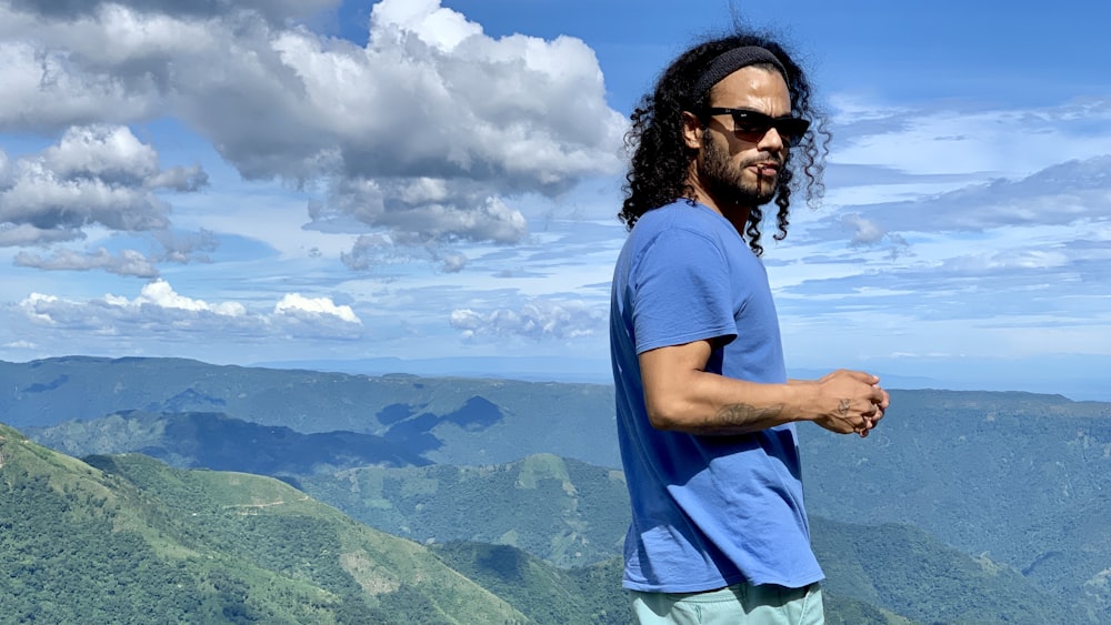 shallow focus photo of man in blue T-shirt wearing black sunglasses