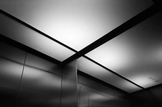 Close-up of a polished elevator cabin interior reflecting soft light.