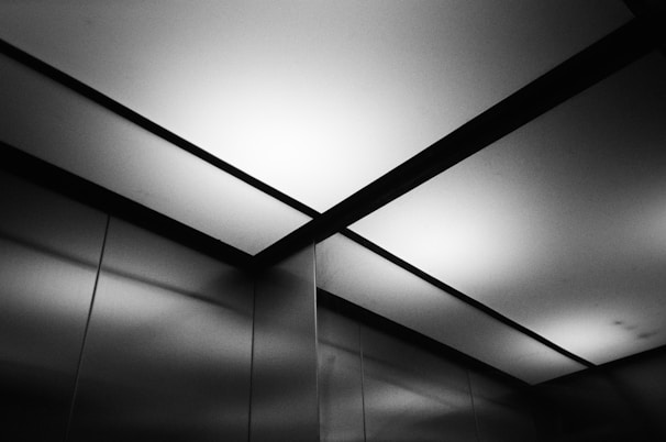 Close-up of a sleek elevator cabin interior with polished stainless steel and warm lighting.