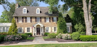 brown bricked 2-story house during daytime