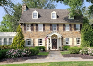 brown bricked 2-story house during daytime