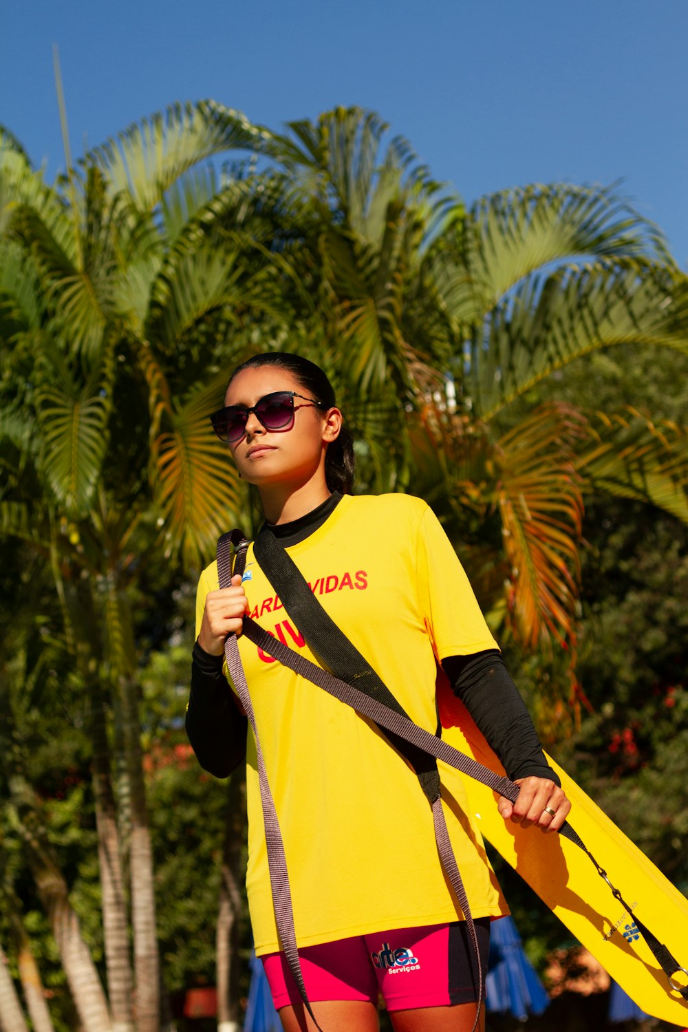woman carrying yellow surfboard