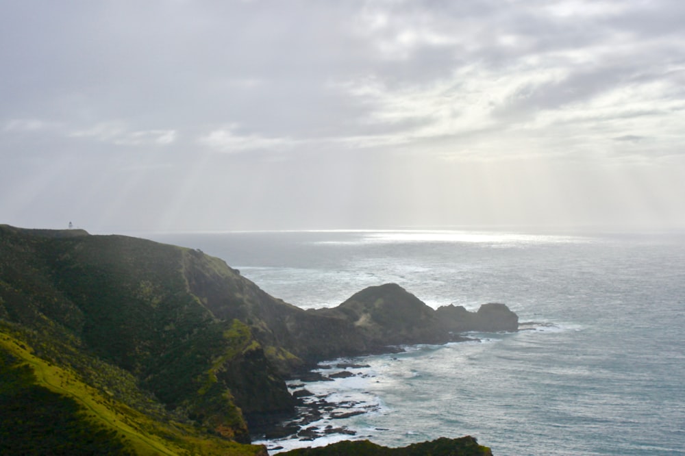 green mountain at shore during daytime