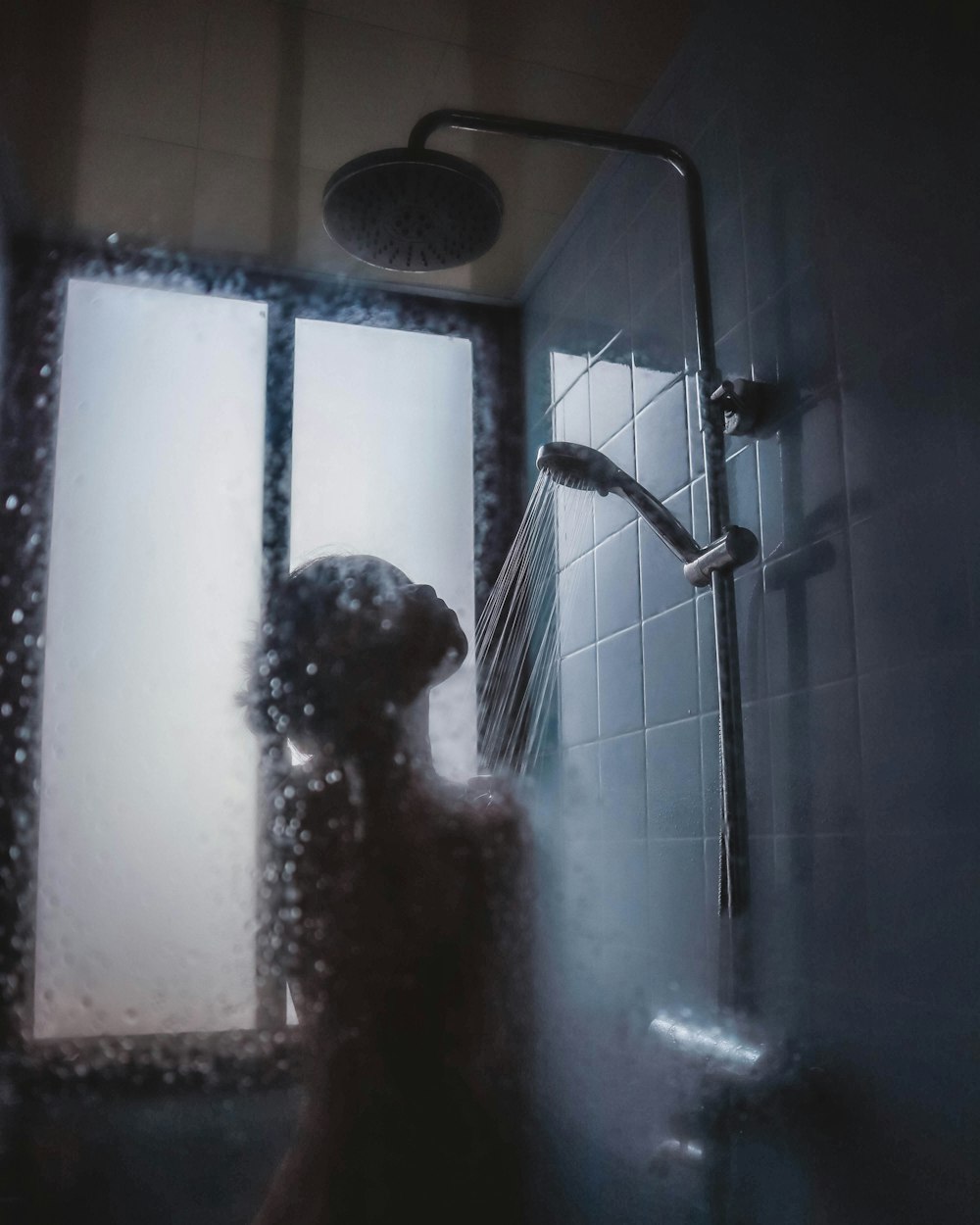 Mujer bajo el cabezal de la ducha
