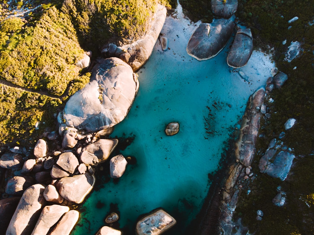 an aerial view of a body of water surrounded by rocks