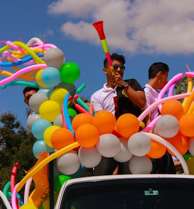 people on back of pickup truck with balloons