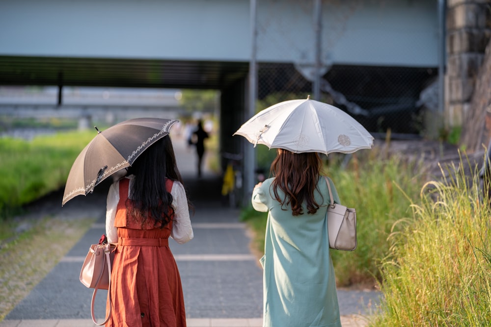two girls carrying umbrellas