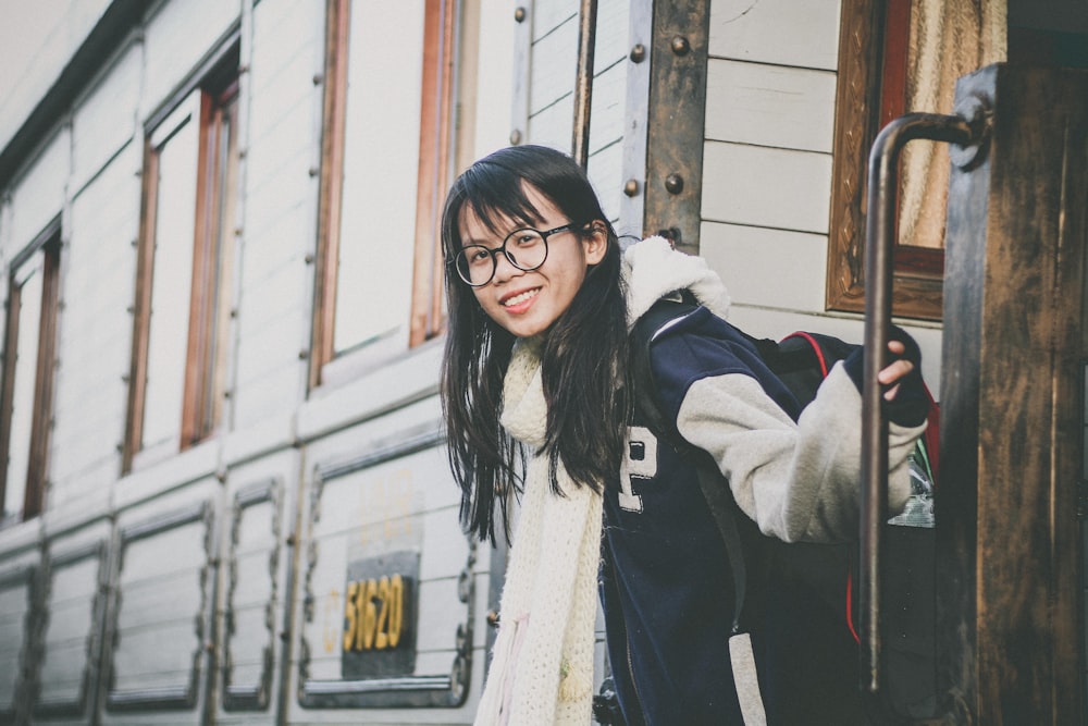 shallow focus photo of woman in black and white jacket wearing eyeglasses