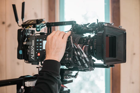 Cinematographer adjusting camera settings while capturing cinematic visuals on location.