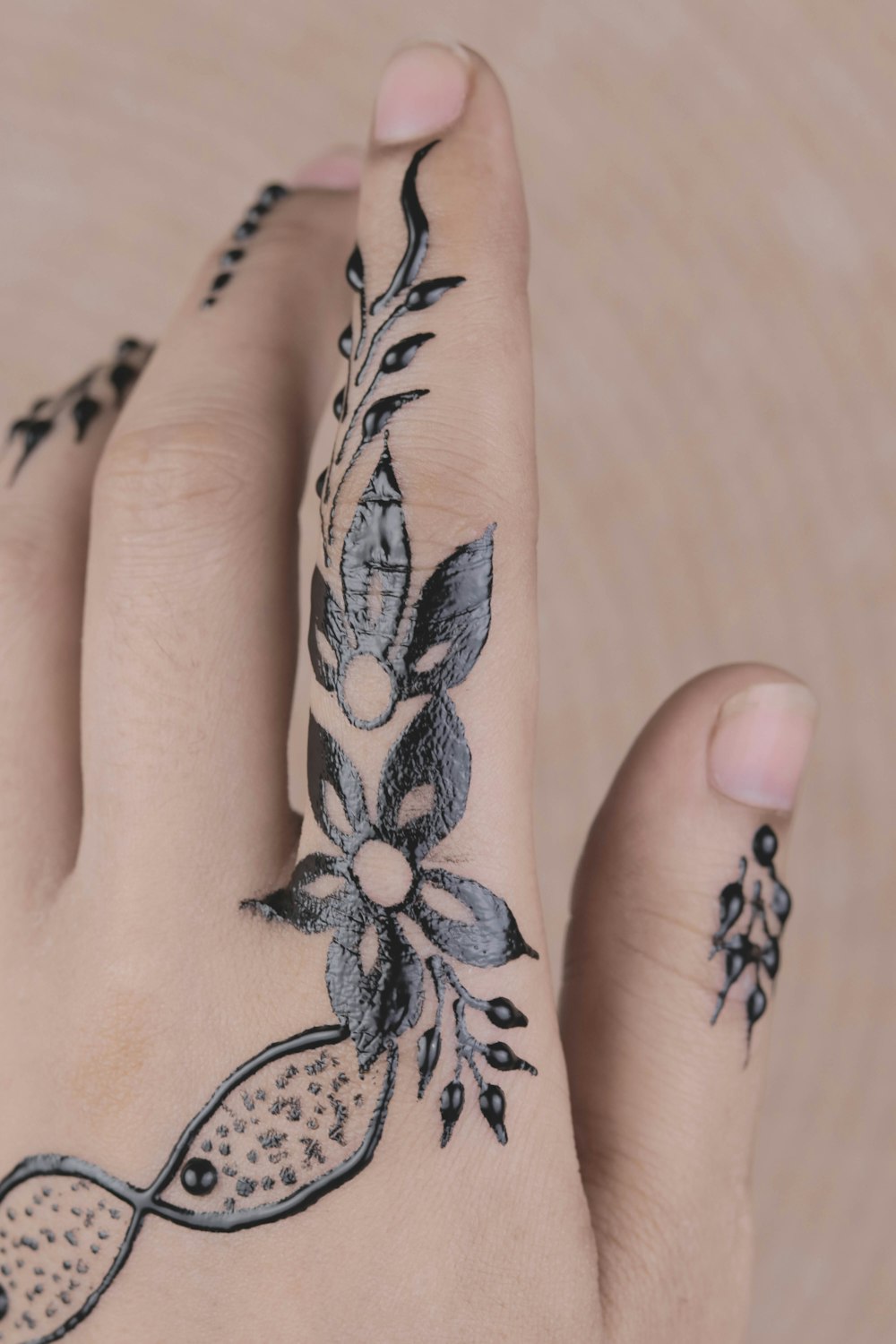 person with black leaves finger tattoos