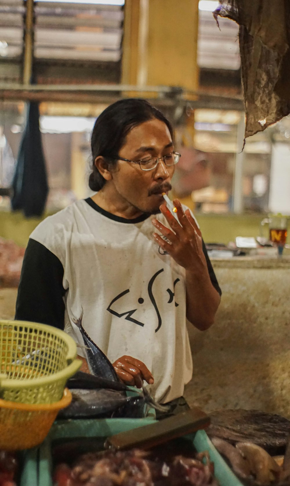 man smoking while holding fish