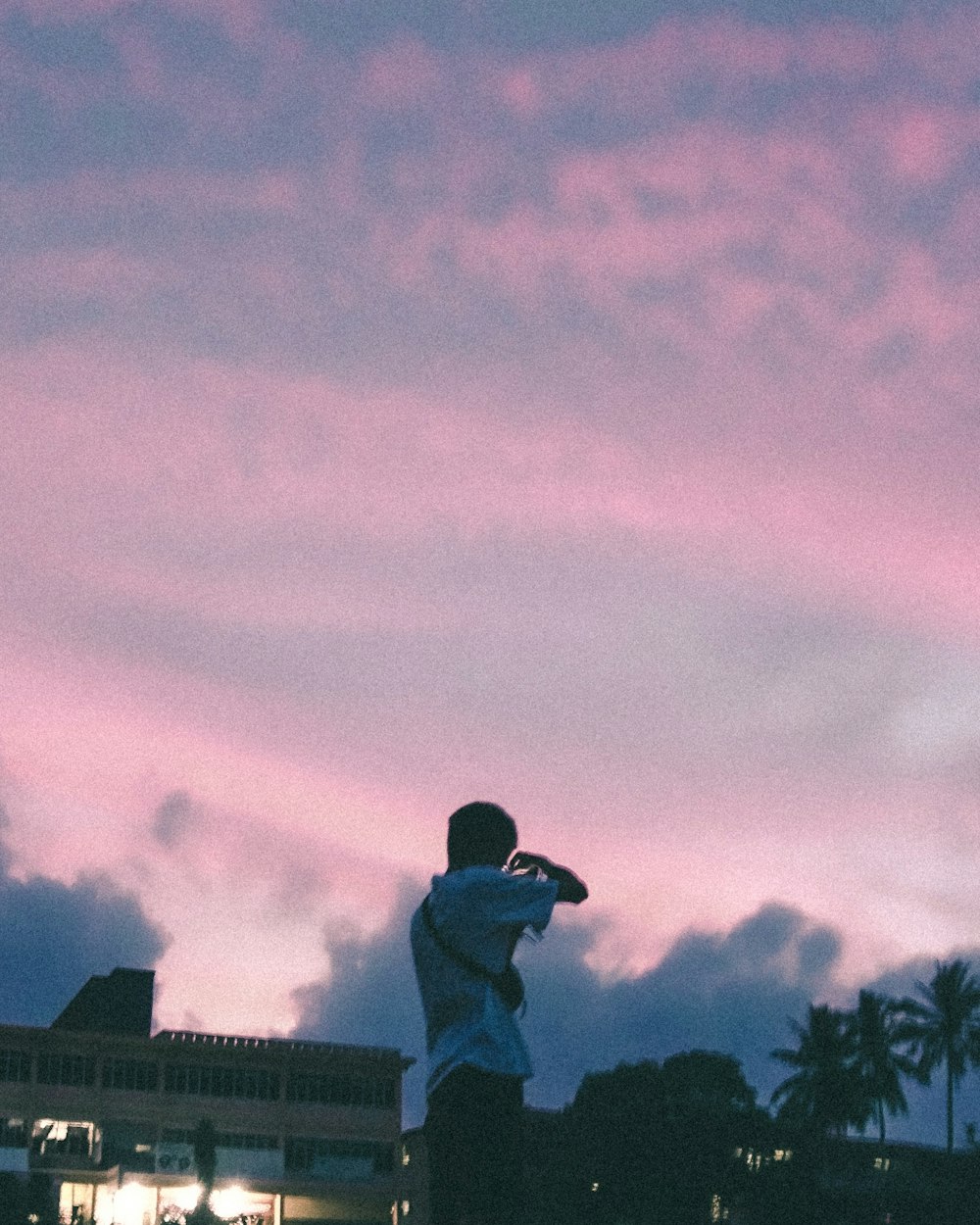 photo of man wearing white polo shirt holding DSLR camera