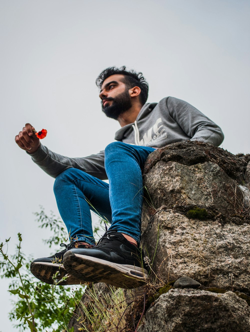 man sitting on peak at daytime