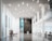 A spacious, modern interior with tall white columns and high ceilings. The floor is polished and reflective. On the left side, there is a comfortable seating area and a glass display, while the right side features modern desks with computer stations. The walls are a mix of white and dark gray panels, and there is ample natural light from large windows.