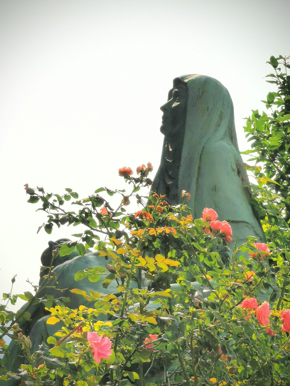 woman statue beside tree at daytime