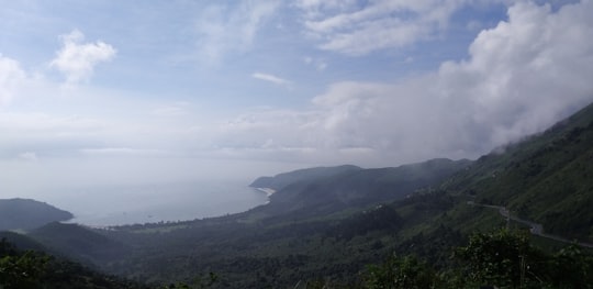 body of water near mountain during daytime in Đèo Hải Vân Vietnam