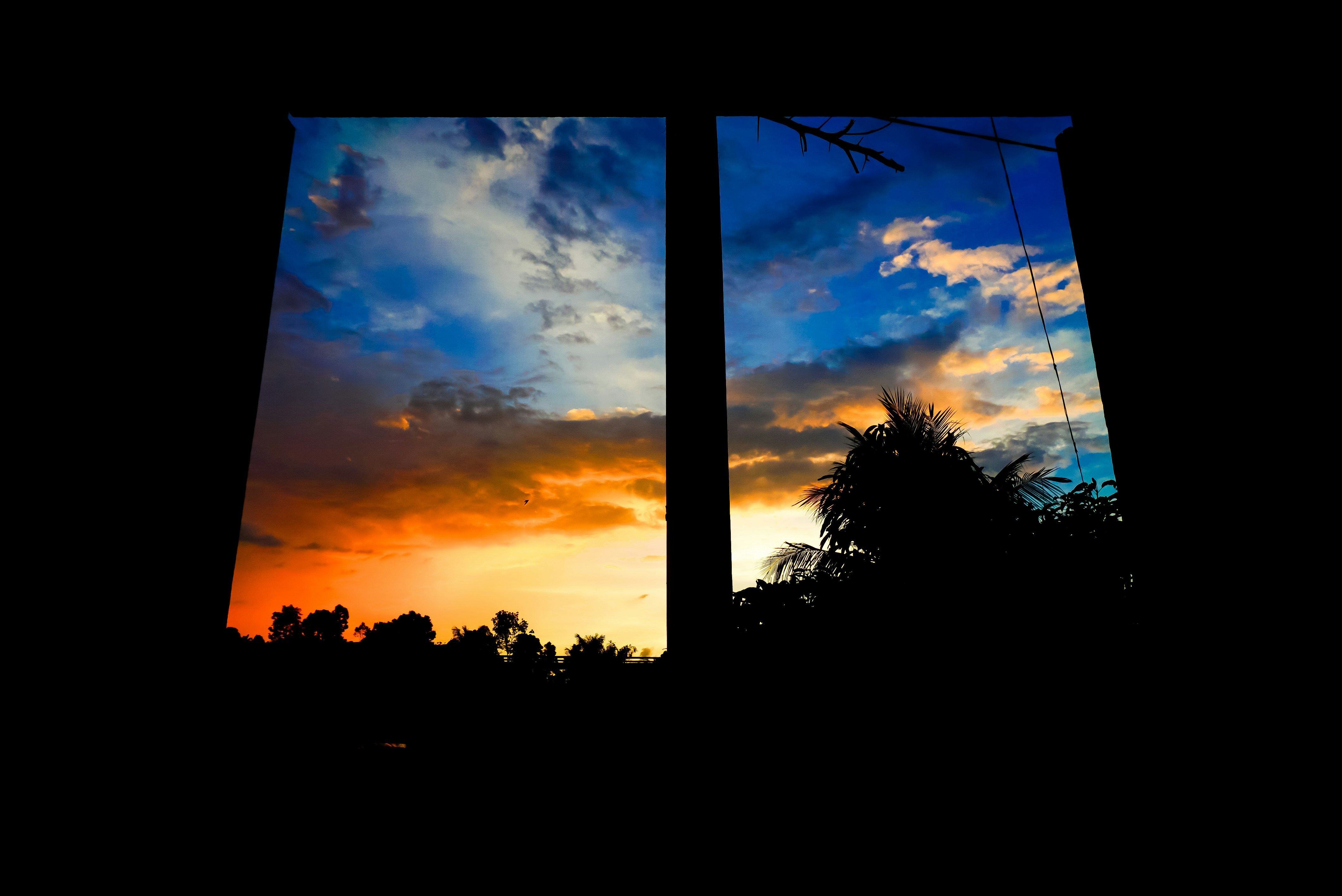 A view of a sunset through two windows photo – Free Building Image on ...