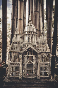 A beautifully crafted tall Thai birdcage with intricate wooden details.