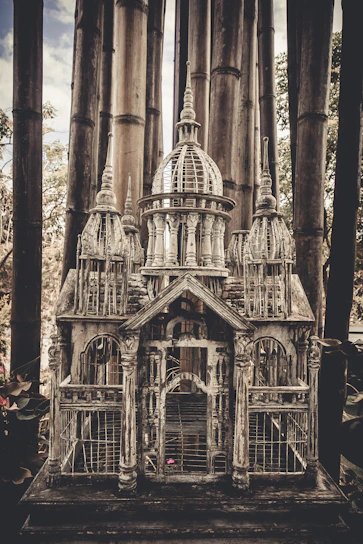 A beautifully crafted tall Thai birdcage with intricate wooden details.