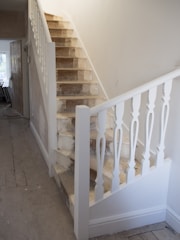 Before and after image of a stairwell renovation showing fresh paint and polished wooden floors.