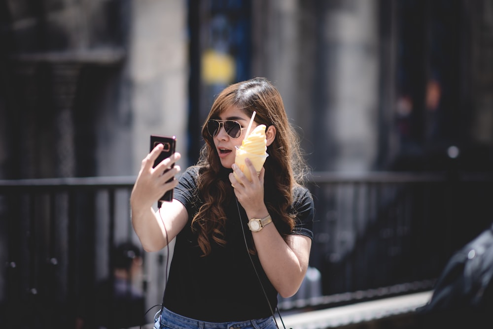 woman in black top taking selfie outdoors