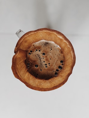 Top view of a W60 dripper sitting on a ceramic mug with rich coffee brewing.