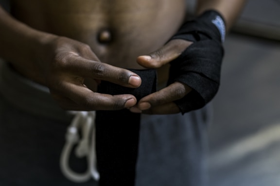 Close-up of a martial artist's hands wrapped in training tape preparing for a fight