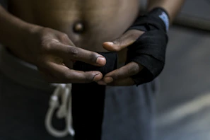 Close-up of hands wrapped in traditional karate gloves preparing for sparring.