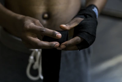A martial artist tying hand wraps before training.