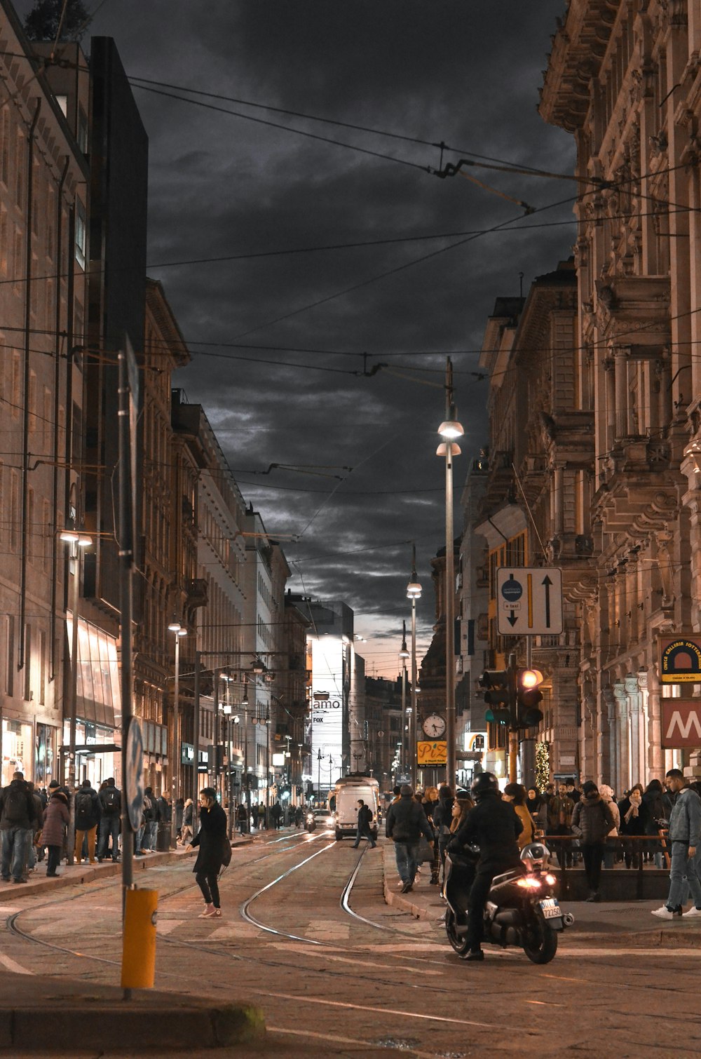 people walking near street beside buildings during night time