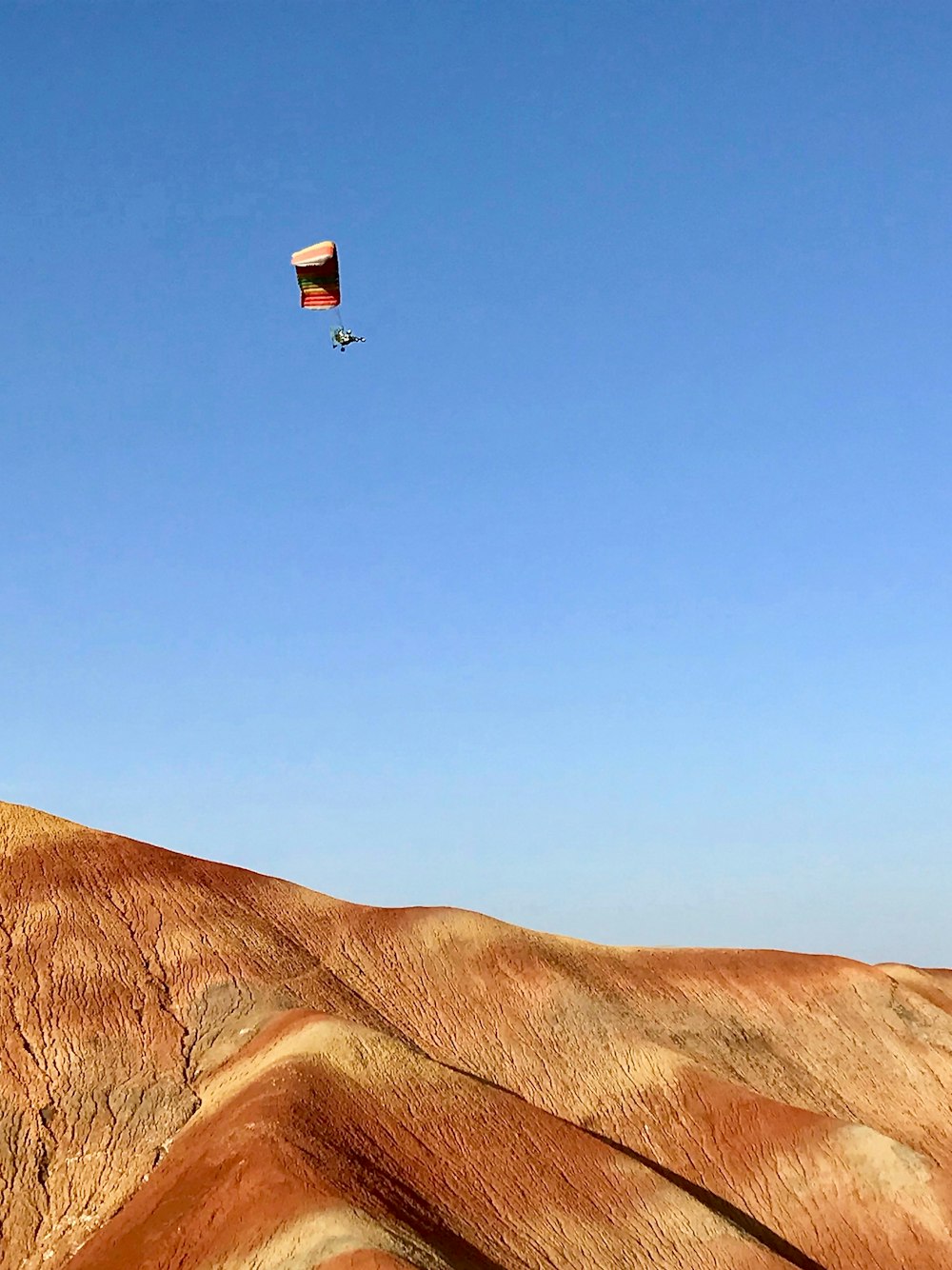 a person flying a kite in a blue sky