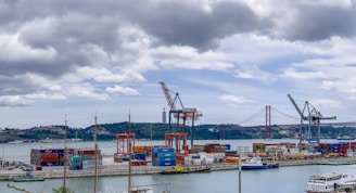 aerial photo of boats near container vans and cranes