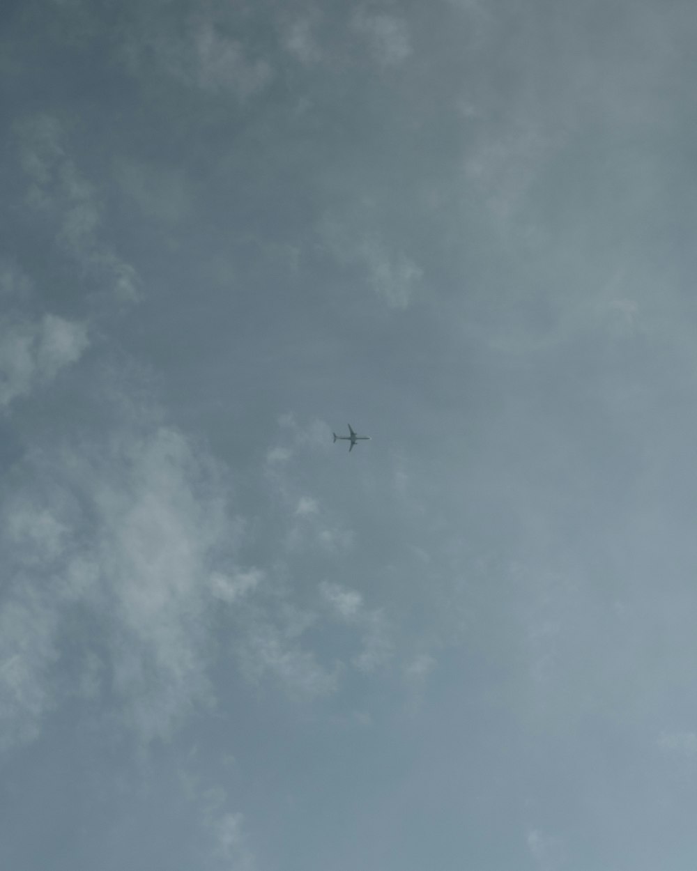 plane under white clouds