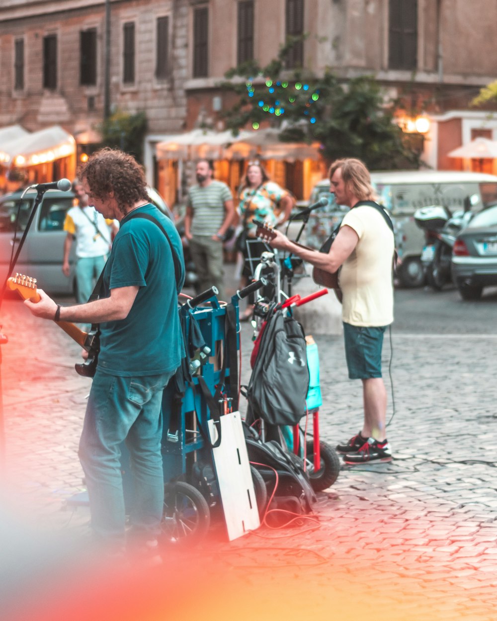 close-up photography of two man playing guitar on street