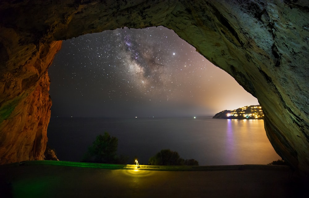 body of water near mountain at nighttime