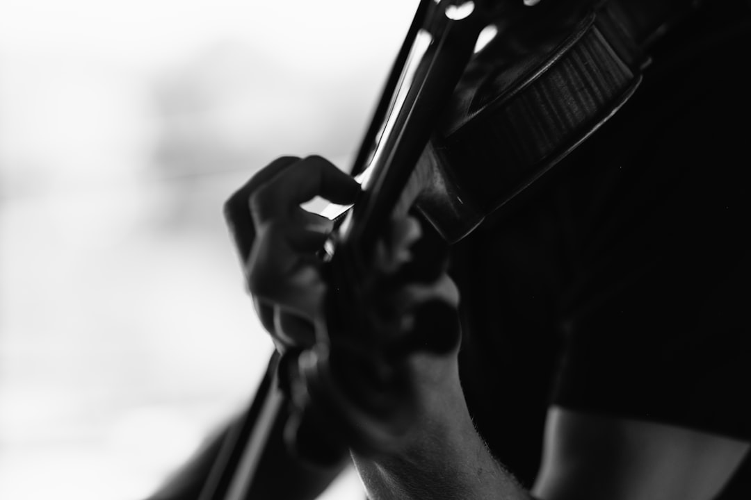 grayscale photography of person playing violin