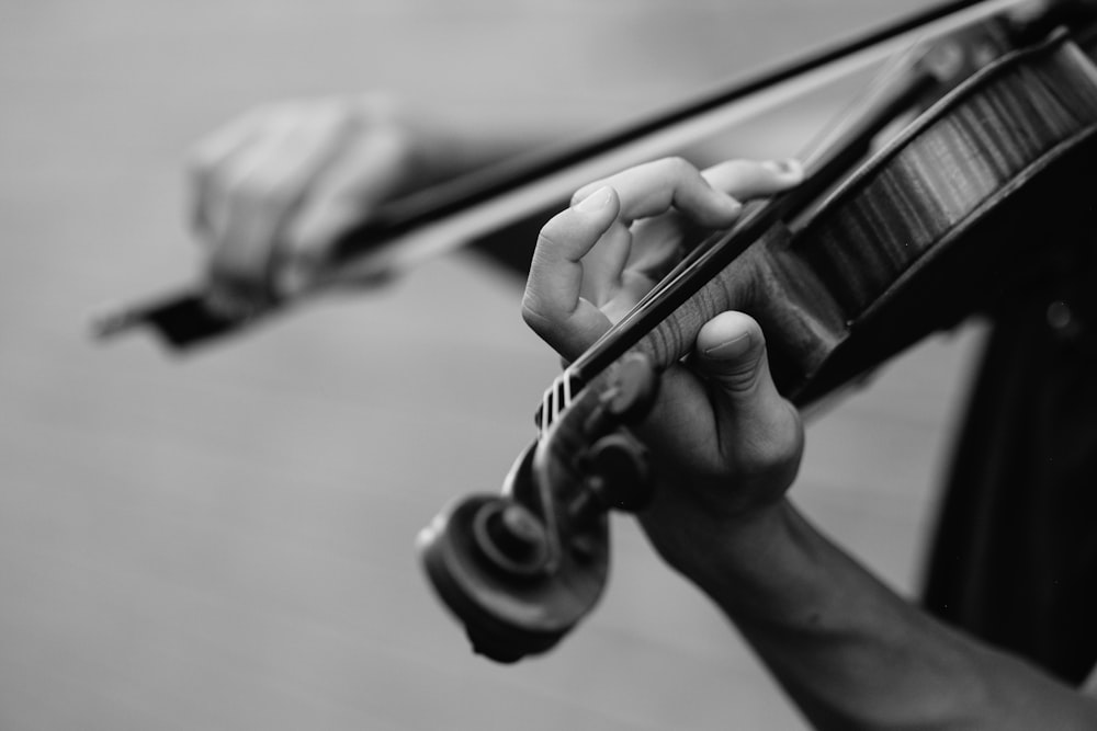 바이올린을 연주하는 사람의 회색조 사진