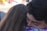 Two people are embracing each other closely, conveying a sense of warmth and affection. The background is slightly blurry, focusing attention on the emotional moment.