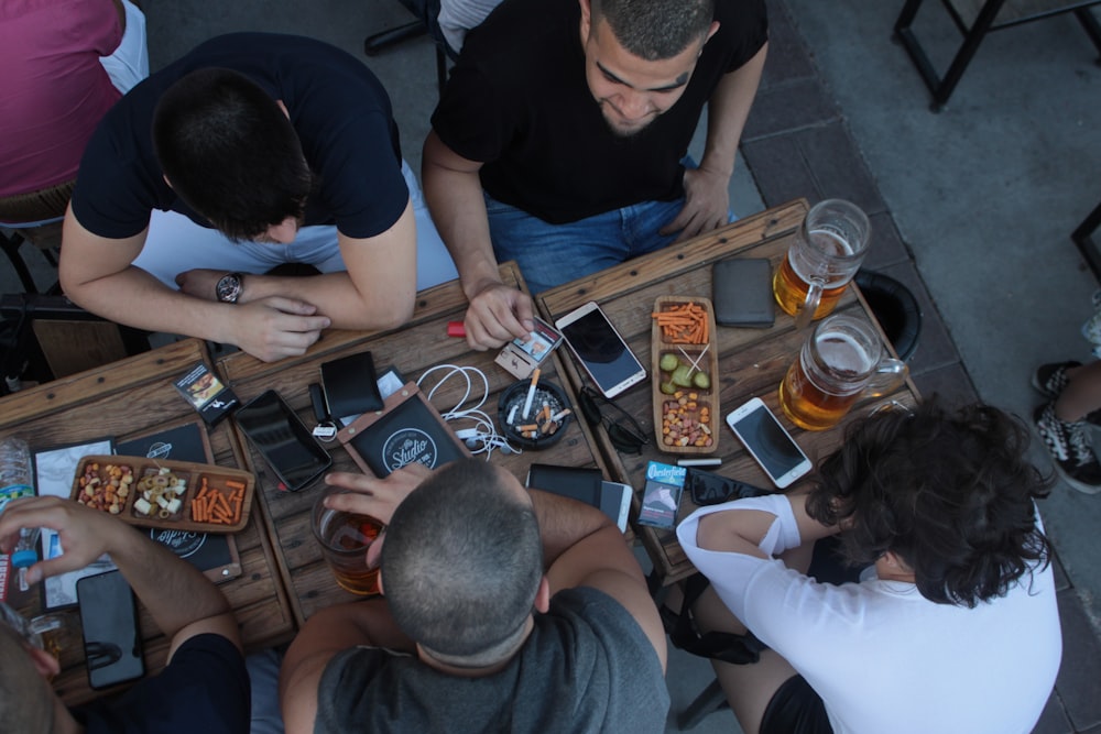 four men sitting on table while drinking