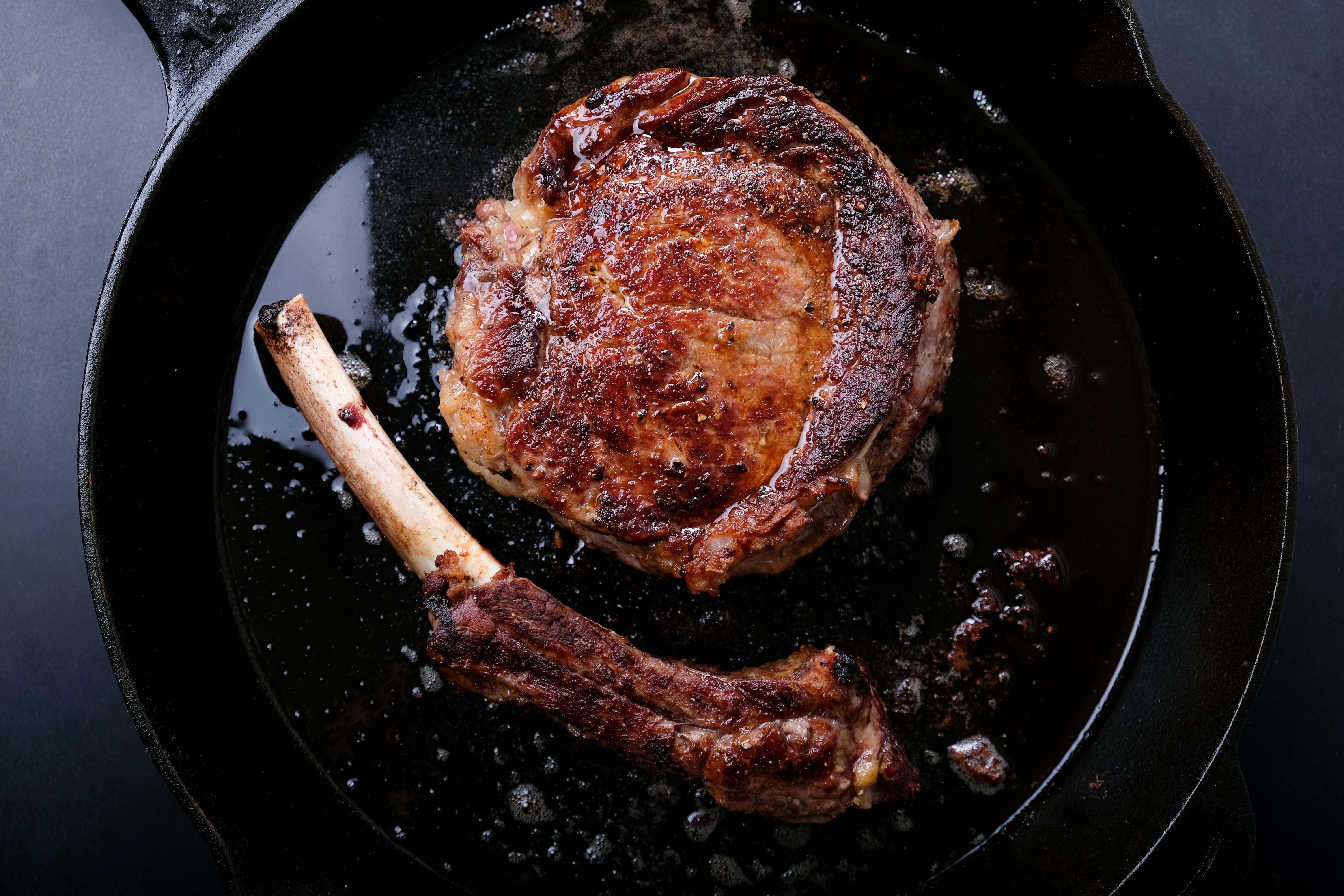 rib steak in a cast iron pan, off the bone