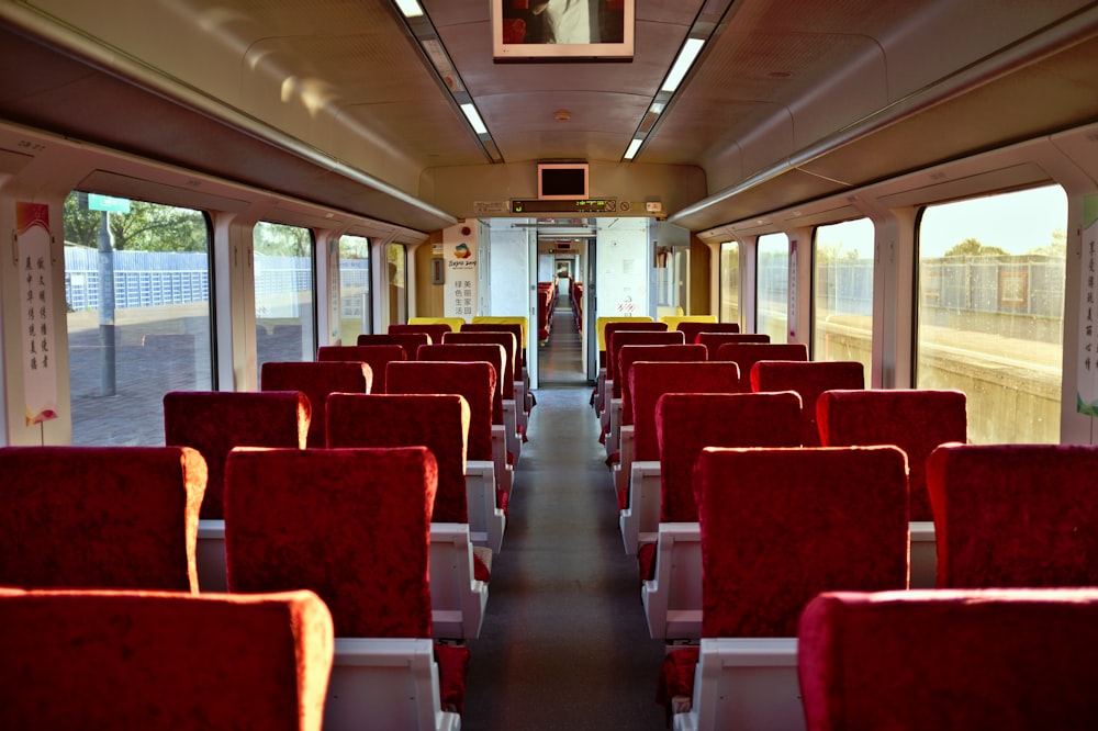 the inside of a train car with red seats