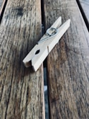 A hand gripping a sturdy stainless steel clothespin.