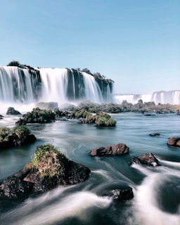waterfalls under clear sky during daytime digital wallpaper