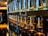 Rows of glass bottles lined up on rustic wooden shelves in a distillery setting.