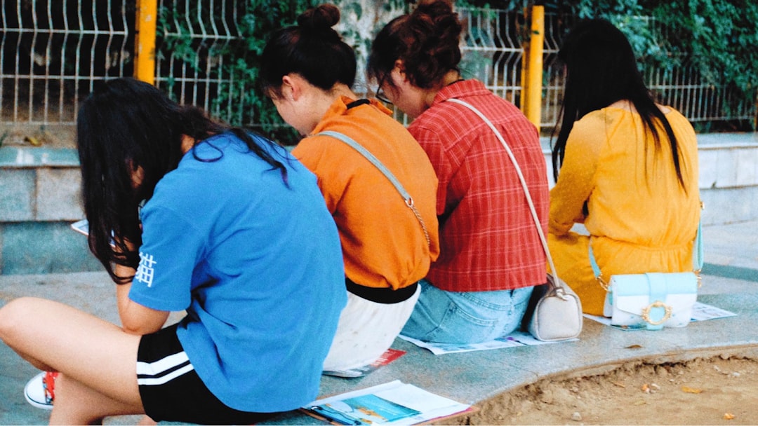 woman wearing blue crew-neck shirt sitting on gray marble bench