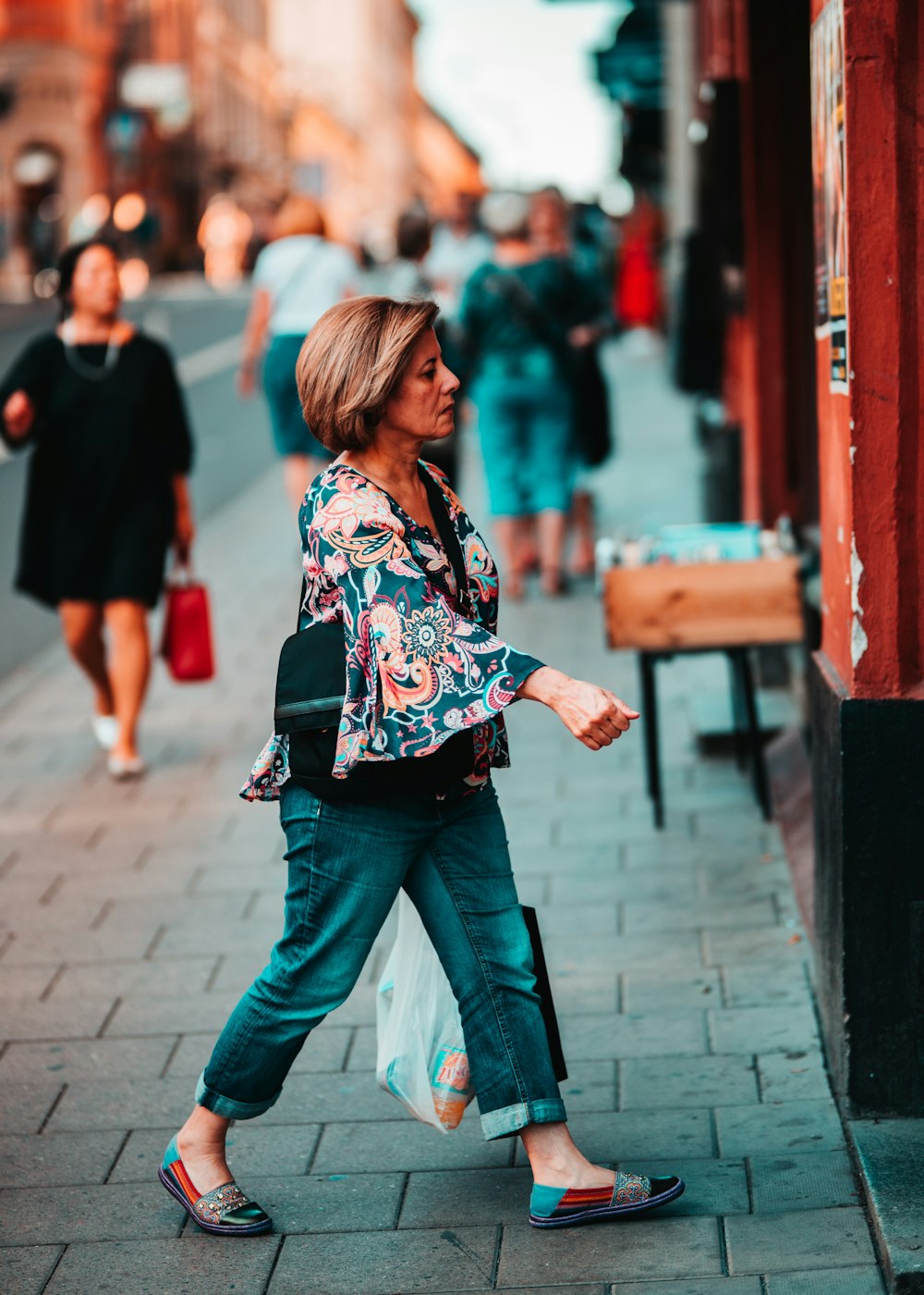 woman wears blue and pink floral blouse